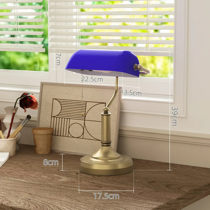 Table lamp with blue glass shade and gold base on a wooden surface, with measurements indicated.