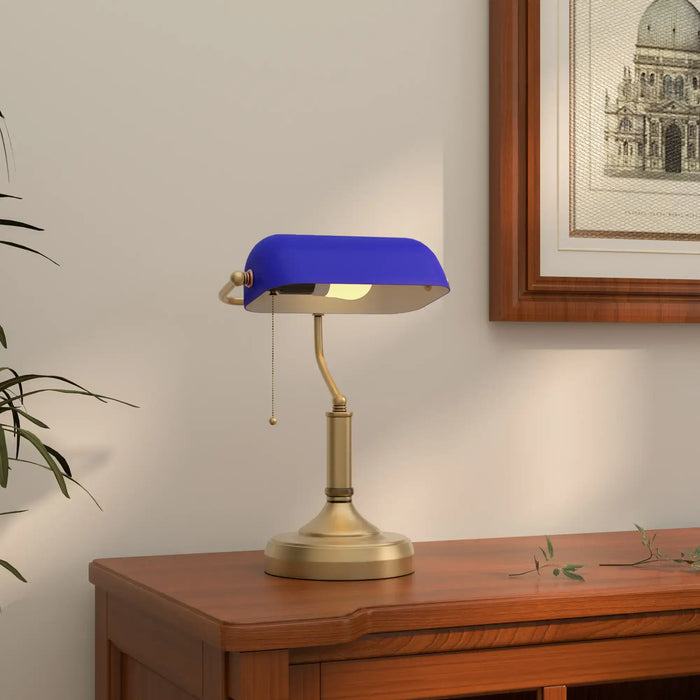 Table lamp with blue shade on a wooden surface, framed picture in the background