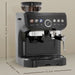 Black espresso machine with a bean grinder attachment, shown with dimensions on a beige background.