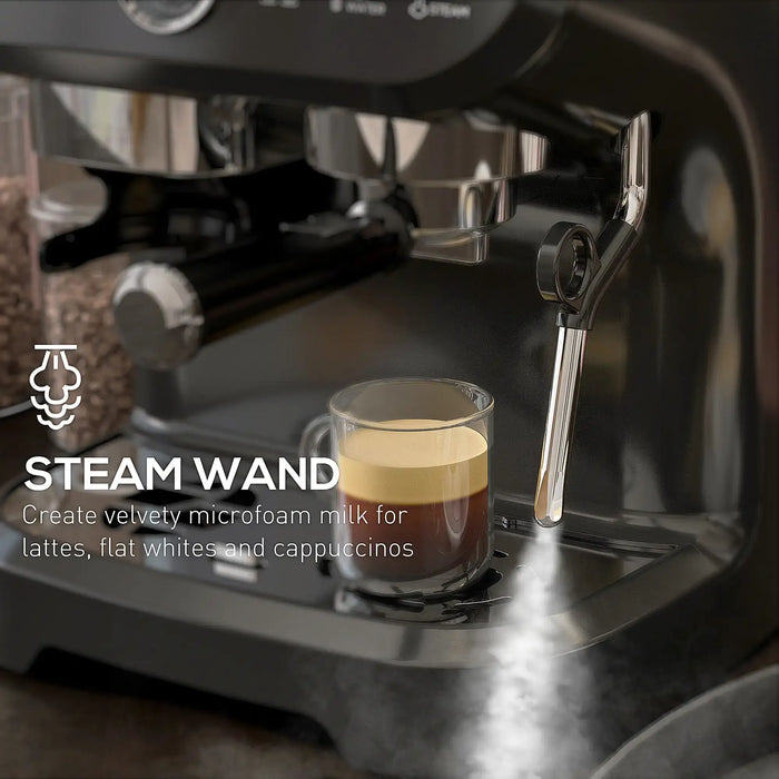 Espresso machine with steam wand and a glass of layered coffee