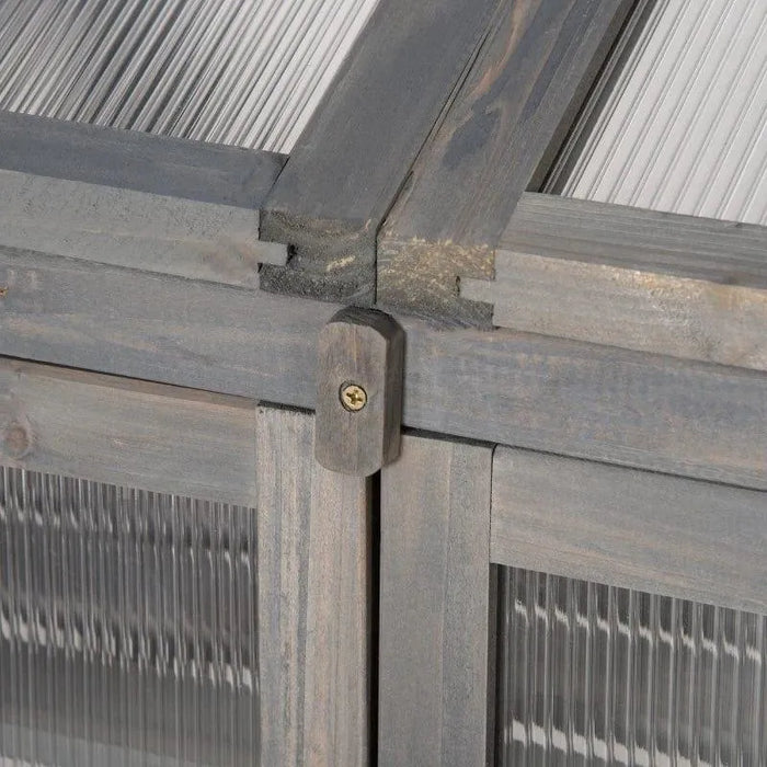 Close-up of grey wood frame and clear polycarbonate panel on cold frame greenhouse