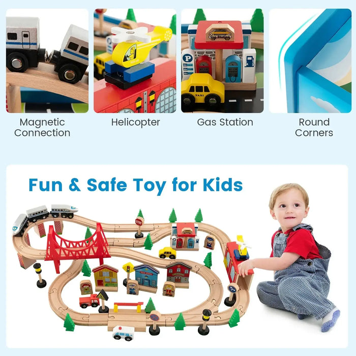 Colorful wooden train table set with tracks, bridges, vehicles, buildings, and a smiling child playing.