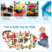 Colorful wooden train table set with tracks, bridges, vehicles, buildings, and a smiling child playing.