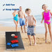 Family playing cornhole game board set on sandy beach, kids in swimsuits, ocean in background