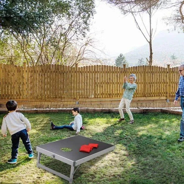 Family playing cornhole game on aluminum frame MDF board set in backyard garden