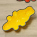 Yellow crocodile-shaped balance stepping stone for kids on light wood floor