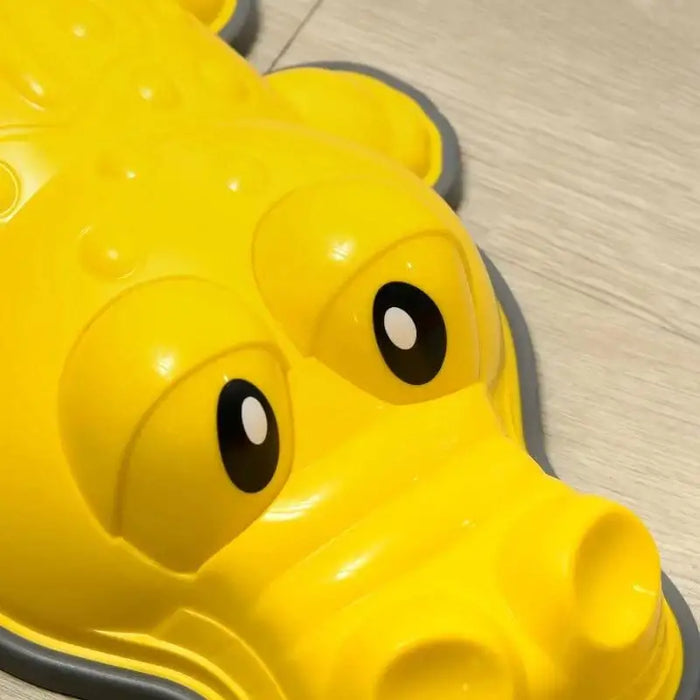 Yellow crocodile balance stepping stone for kids on a light wood floor