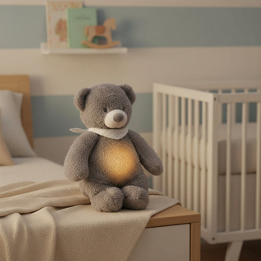 Grey teddy bear night light with glowing belly and white scarf, cry-activated sleep aid