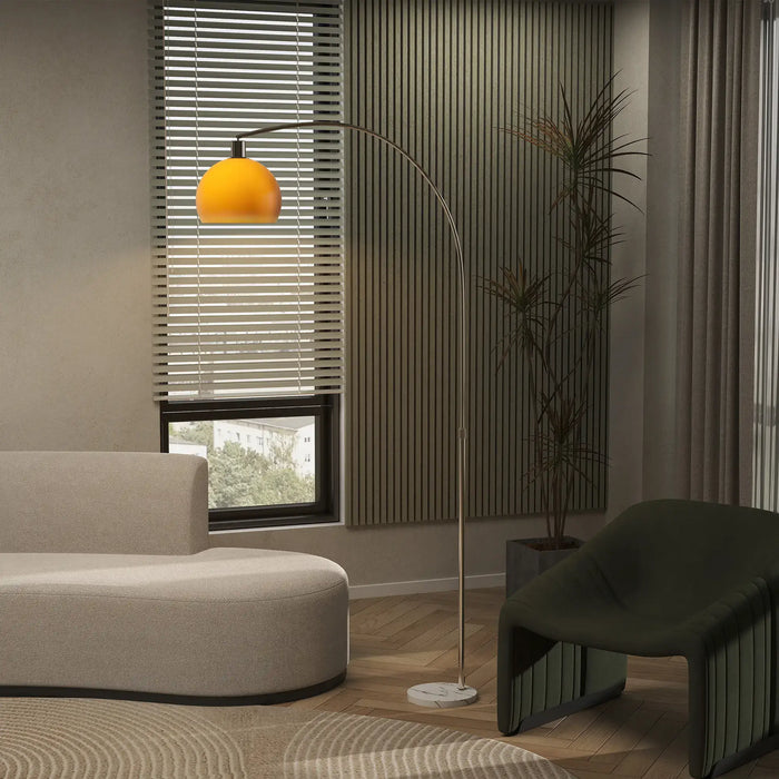 Modern living room with a beige sofa, green chair, and a floor lamp with an orange shade.