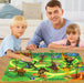 Man with two children playing with a dinosaur toy set on a map
