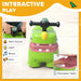 Green toy with interactive features on a white background