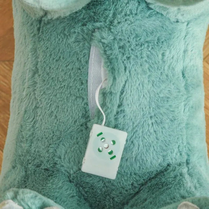 Close-up of sound button inside plush green dinosaur rocking horse toy