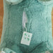 Close-up of sound button inside plush green dinosaur rocking horse toy