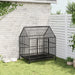 Heavy duty galvanized steel dog cage with wheels in garden, beside white fence and wall