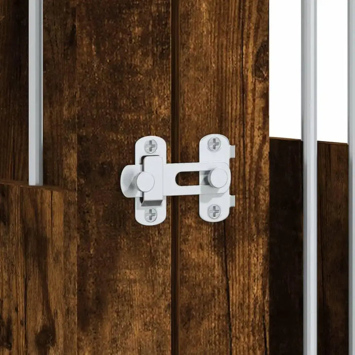 Close-up of lockable door latch on smoked oak dog crate furniture with metal bars
