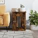 Smoked oak dog crate furniture end table with lockable door beside sofa, books and plant on top