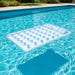 Double inflatable beach bed with dual air chambers floats in a clear blue swimming pool