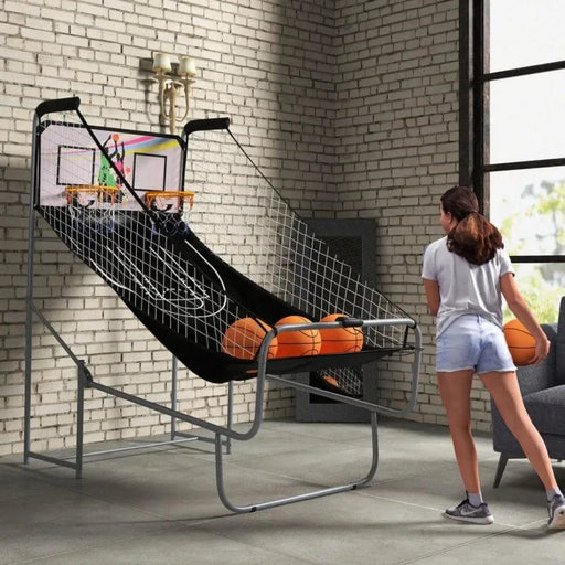Girl playing double shot basketball arcade game with electronic scoreboard indoors