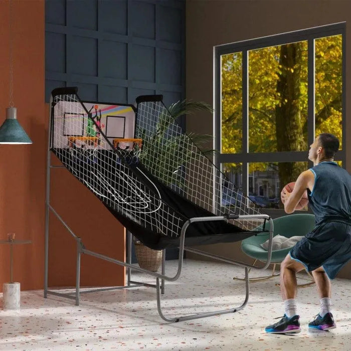 Man playing double shot basketball arcade game with electronic scoreboard in modern room