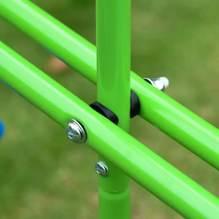Close-up of green metal swing set frame bolts on grass background.