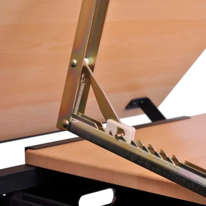 Close-up of adjustable drafting table tilting mechanism on wooden worktop