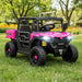 Pink and black toy off-road vehicle on grass with trees and flowers in the background