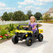 Child in a toy vehicle on a driveway with a garden and house in the background