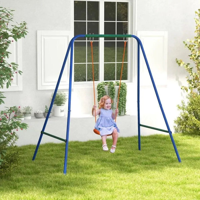 Child on blue metal A-frame outdoor swing set with grass lawn and white house background