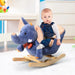 Baby sitting on blue plush elephant rocking horse with wooden base in nursery room