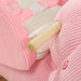 Close-up of pink textured fabric with a wooden stick and white strap.