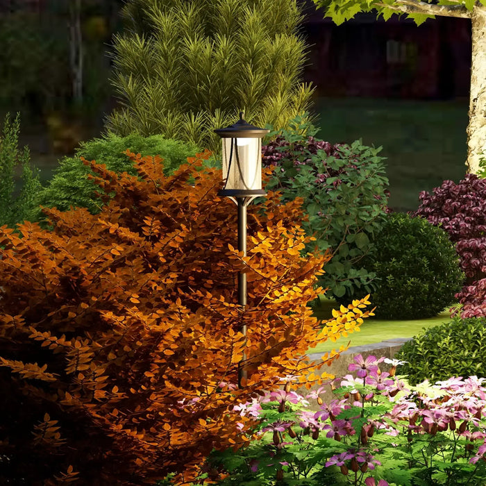 Outdoor garden scene with solar lantern surrounded by vibrant autumn foliage and blooming flowers