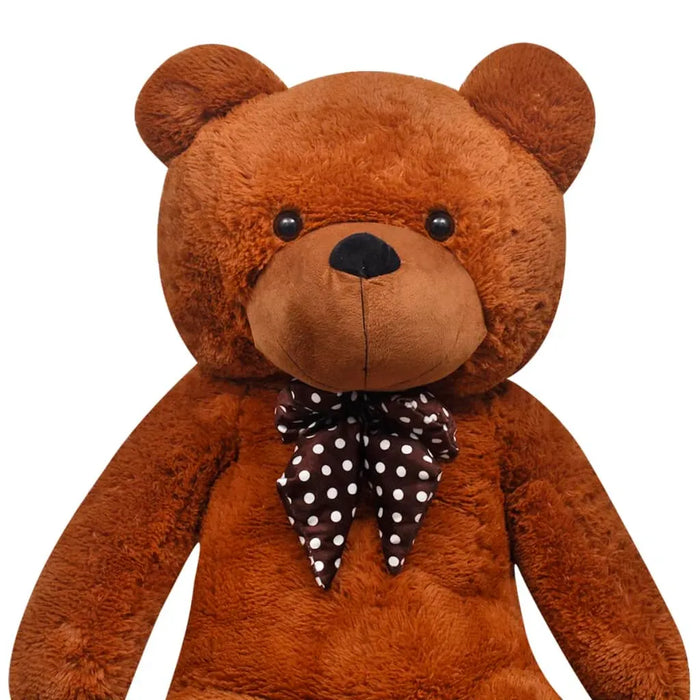 Brown teddy bear with a polka dot bow tie on a white background