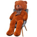 Large brown teddy bear with a polka dot scarf sitting on a gray chair against a white background