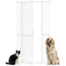 White metal pet safety gate open with black and white cat and golden retriever dog sitting beside it