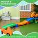 Children's toy track with orange cars on a green and brown floor, featuring text about indoor and outdoor use.