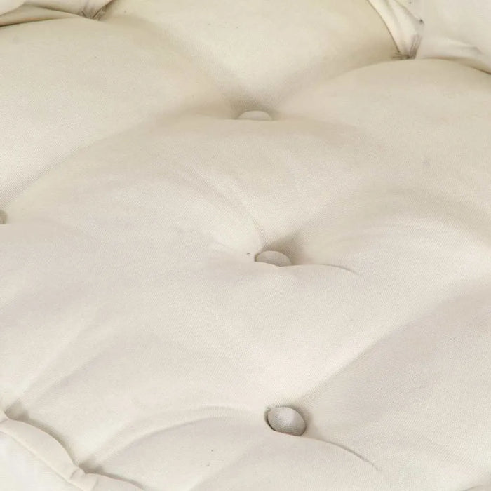 Close-up of a tufted beige cushion with button details