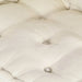 Close-up of a tufted beige cushion with button details