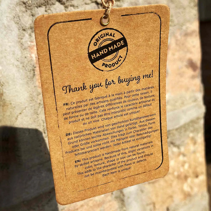 Kraft paper tag with 'Original Handmade Product' text on a stone background
