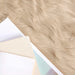 Close-up of light brown fur texture with a white card and beige paper underneath.