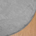 Gray fluffy rug on a wooden floor