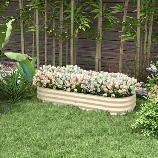 Cream flexible raised garden bed planter with white and pink tulips in a backyard with bamboo and green grass
