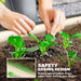 Hands tending green leafy plants in a cream raised garden bed with safety rubber-edged design