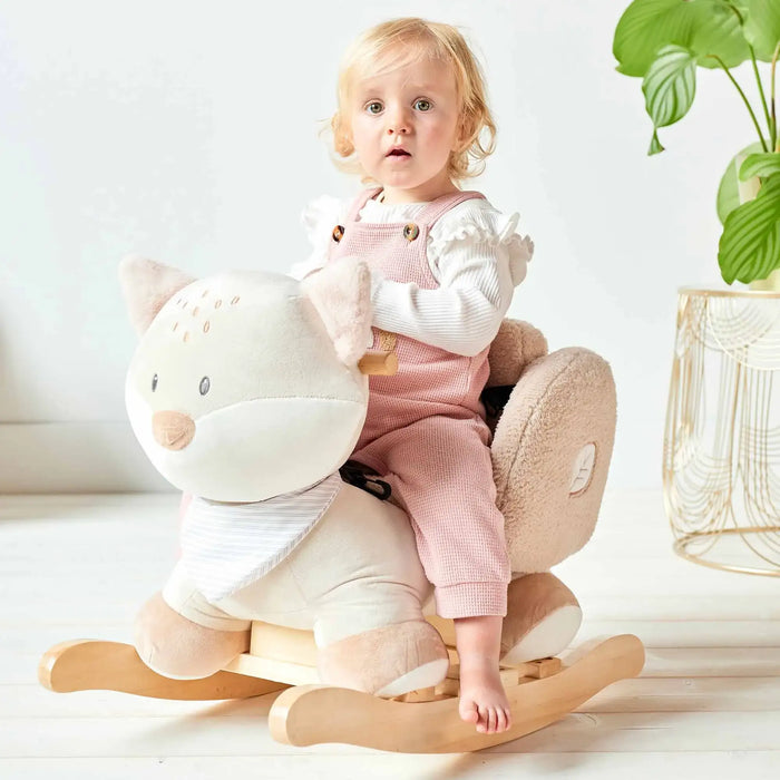 Child sitting on a rocking toy with a white background