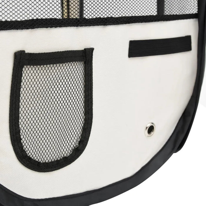 Close-up of foldable dog playpen in black and cream with mesh pocket and carry handle