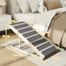 Wooden pet ramp with gray carpet strips beside bed in bedroom, dimensions labeled
