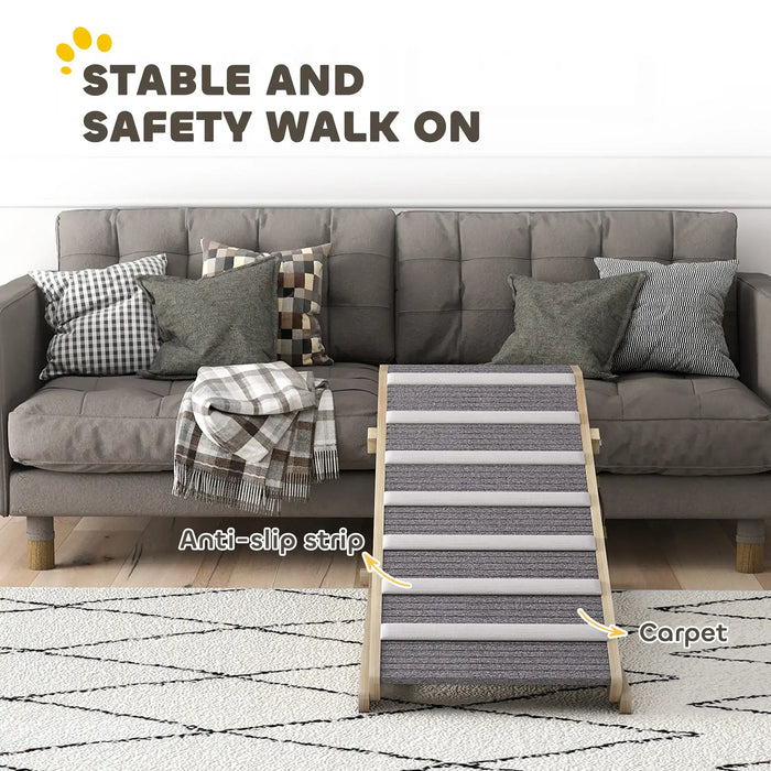 Gray pet ramp with anti-slip strips and carpet in front of a gray sofa with patterned pillows and blanket