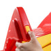 Close-up of hand assembling red and yellow foldable kids slide for indoor outdoor play.