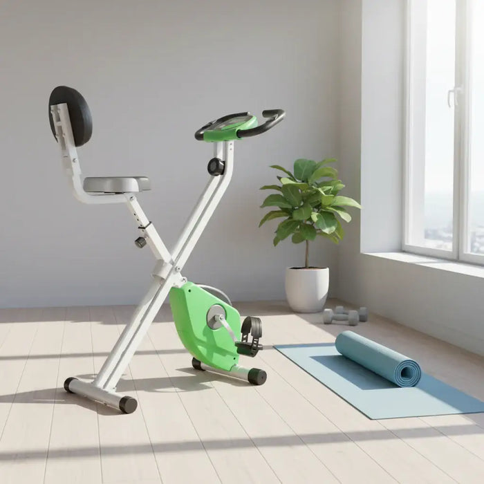 Green and white exercise bike in a room with a plant and yoga mat.