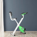 Green and white exercise bike against a dark blue wall.