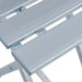 Close-up of silver folding aluminum camp stool with slatted seat, lightweight design